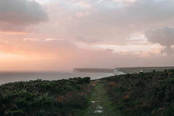 イギリスのイーストサセックスの南岸で最も長い未開発の海岸線の一つであるセブン シスターズ チョーク クリフの風景道は日没時に — ストック写真