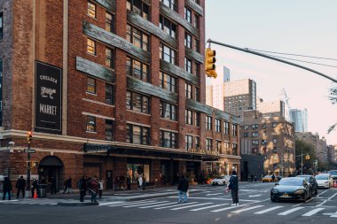 New York, ABD - 21 Kasım 2022: İnsanlar 9. Cadde 'yi Chelsea Market, bir gıda salonu, alışveriş merkezi, ofis binası ve Manhattan' daki televizyon üretim tesisi önünde geçtiler.