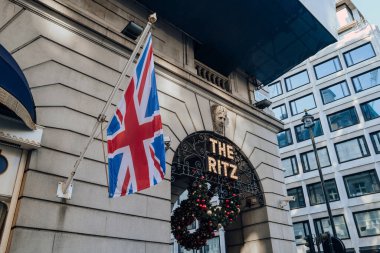 Londra, İngiltere - 26 Aralık 2022: Londra 'nın en ikonik oteli Ritz' in dışında imzala, bir direğin üzerinde Union Jack bayrağının yanında.
