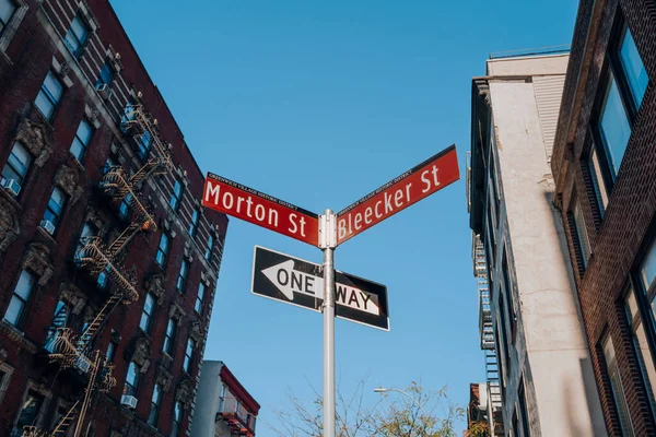 Street name signs on the corners of Morton and Bleecker streets in Greenwich Village, New York City, USA.