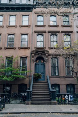 New York, USA - November 21, 2022: Exterior of a traditional house with a stoop in West Village, a charming area of Manhattan famous for its shops and restaurants.