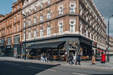 Londra, İngiltere - 13 Nisan 2023: İnsanlar Tottenham Court Road 'da Victoria tarzı meşe panelli geleneksel bir bar olan The Jack Horner' ın önünde yürüyor.