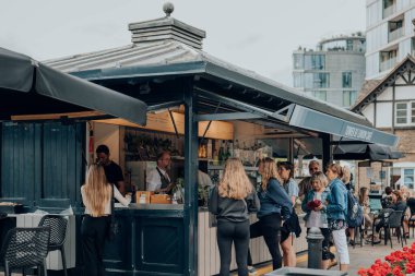 Londra, İngiltere - Temmuz 06, 2023: Londra 'nın en önemli turizm merkezlerinden biri olan Londra Kulesi' nin yanındaki Thames nehri kenarındaki kafeden yiyecek ve içecek satın alan insanlar.