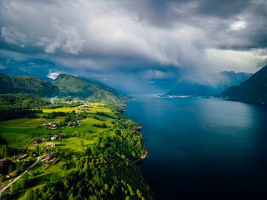 Romsdalen Vadisi, Rauma Nehri ve Norveç 'teki Trollveggen Dağları manzaralı. Romsdal Fjord ve Endülüs şehri sahnenin sağ üst köşesindeler..