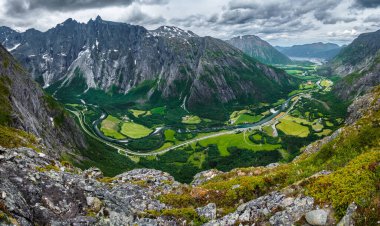 Romsdalen Vadisi, Rauma Nehri ve Norveç 'teki Trollveggen Dağları manzaralı. Romsdal Fjord ve Endülüs şehri sahnenin sağ üst köşesindeler..
