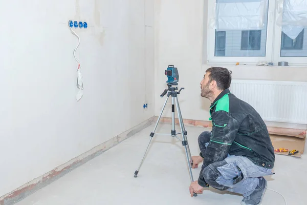 Adam Yeni Apartman Dairesinde Tamirat Yapıyor Nşaatçı Lazer Seviyesini Kullanarak — Stok fotoğraf