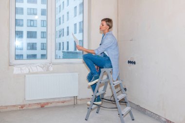 Yeni daireye yeni bir hayat kuran bir kadın. Yeni dairede tadilat var. Ev onarımı. Yüksek kalite fotoğraf