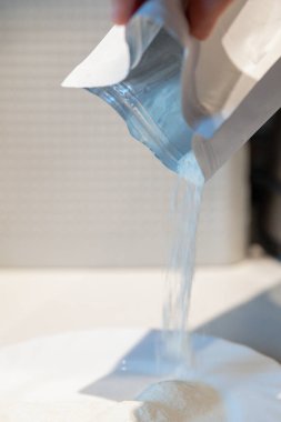 Kadınlar beyaz tozu paketten tabağa ilaç ile doldurur. Yüksek kalite fotoğraf