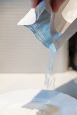 Kadınlar yemek pişirmek için paketten tabağa un döker. Yüksek kalite fotoğraf