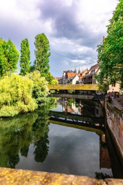 Nuremberg, Almanya - 26 Temmuz 2023: Nuremberg 'in yarı ahşap evlere sahip renkli tarihi kasaba. Pegnitz nehri üzerindeki köprüler. Nurnberg, doğu Bavyera, Almanya. Dikey fotoğraf