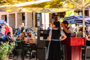 Münih, Almanya - 22 Temmuz 2023: Sokak restoranı ve ulusal kostümlü garsonlar Münih, Bavyera, Almanya 'daki Marien Meydanı' nın meydanında