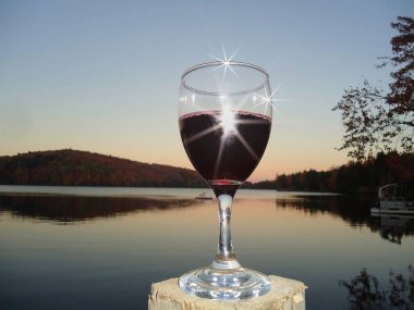 Sakin bir yerde bir bardak şarap dinlenmenin zevkidir. Fotoğraf bir Quebec gölünün yakınında çekildi. Kanada, 9 Ekim 2011.