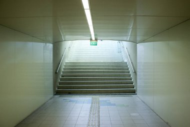 Yeraltı geçidinde merdiven üzerinde bir çıkış işareti var..