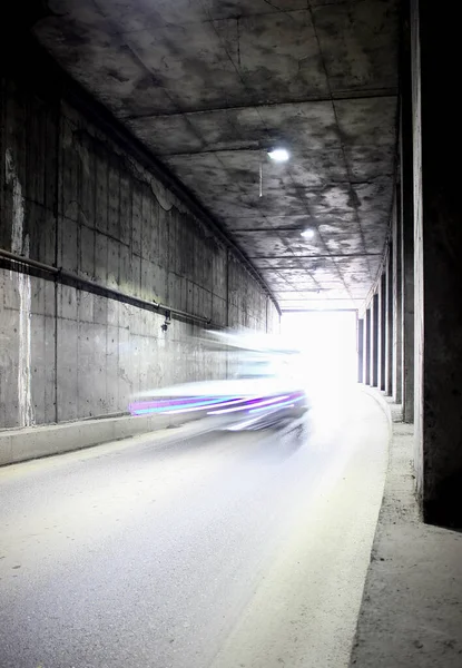 Dark tunnel with moving vehicle. Tunnel with light trails.