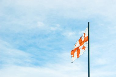 View of The Georgian National Flag against  the blue sky.