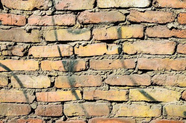 Old brick wall with black paint strokes. Grungy brick wall background.