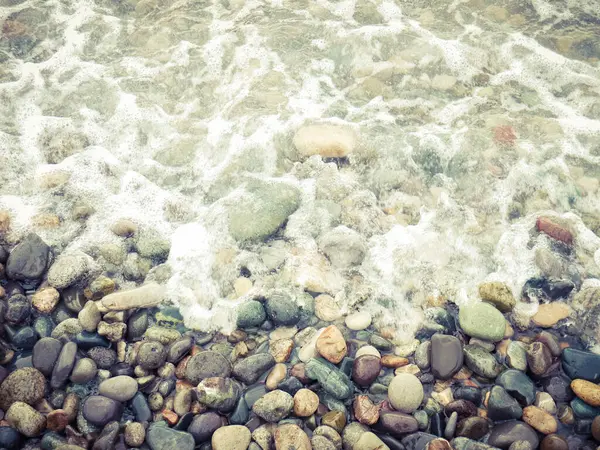 海滩上有卵石和泡沫 — 图库照片