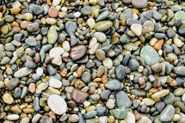 Sahilde renkli çakıl taşları. Islak taşlar arka planı.