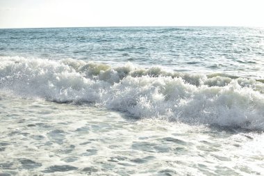 Denizde büyük dalgalar. Parlak sabah güneşinin altında su sıçratan güzel deniz..