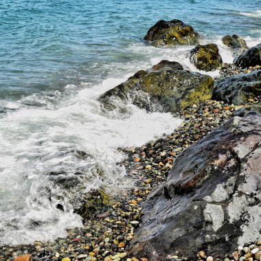 Su ile güzel deniz kıyısı güzel taşlar ve renkli çakıl taşları yıkıyor. Doğanın güzelliği