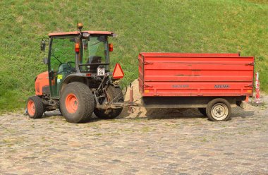 Small red tractor in the park. clipart