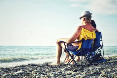 Batumi, Georgia. November 13, 2024. Elderly man sitting on a small chair on the beach in Batumi. clipart