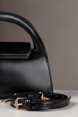 Yakın plan siyah deri çanta, çıkarılabilir kayış ve altın donanım, prim işçiliği ve modern tasarım..