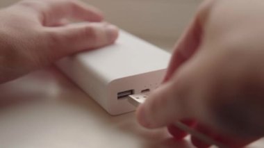 Powerbank 'in dış bataryası masanın üzerinde duran akıllı telefonu şarj ediyor. Gösterge yanıp sönüyor. - Evet. Yüksek kalite 4k görüntü