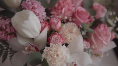 Elegant bouquet of pink roses and other flowers captured in beautiful slow-motion footage. Ideal for a wedding or anniversary celebration. 4k resolution, pan shot. 