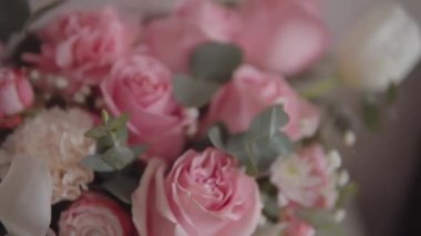 Festive bouquet of pink roses and other flowers captured in beautiful slow-motion footage. Ideal for a wedding or anniversary celebration. 4k resolution, pan shot. 