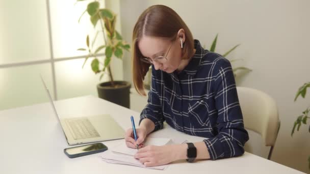 Freelancer Mulher Usando Óculos Fones Ouvido Escrevendo Notebook Office Desk — Vídeo de Stock
