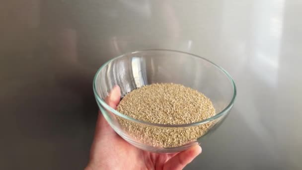 Hand Holds Raw Quinoa Seeds Glass Bowl Super Food Gluten — Stock Video