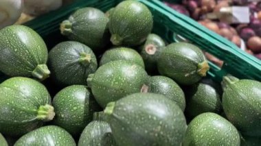 Yerel bir süpermarkette organik ürünler sergilenen bir sürü taze yeşil kabak. Yüksek kalite 4k görüntü.
