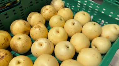 Süpermarkette bir sürü Asya armut meyvesi satılıyor. Bir sürü sarı sulu Çin armudu. Markette satılık taze Asya armudu. Yüksek kalite 4k görüntü.
