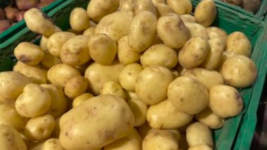 Sebze standında yeşil plastik bir sepetin içinde taze patates. Yüksek kalite 4k video.