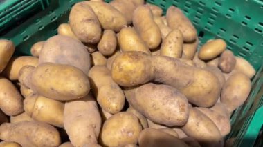 Kaba derili bir patates yığını, bir sandıkta sergileniyor, muhtemelen bir markette ya da markette. Yüksek kalite 4k görüntü.