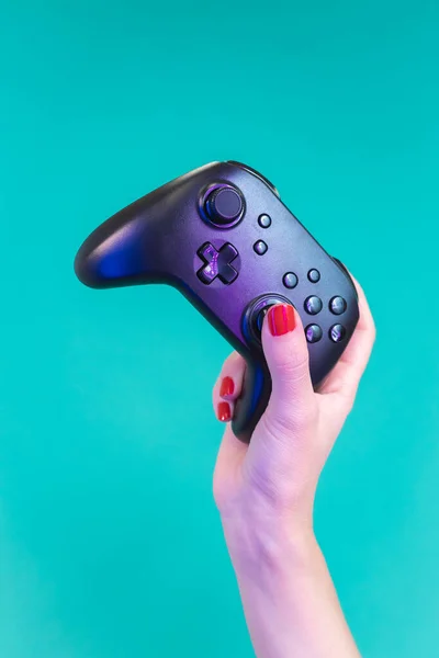 ネオンスタジオライト クローズアップで青の背景にジョイスティックのゲームパッドを保持女性の手 ビデオゲームレジャー中毒性競争の概念 垂直高品質の写真 — ストック写真