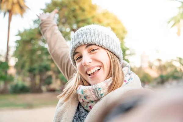 Young woman taking selfie on the street having fun in winter day. High quality photo