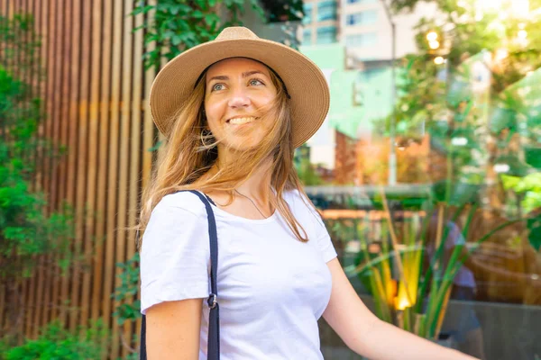 Happy woman tourist walking on the street wit hat on summer holidays enjoying travelling on vacation, sunny lifestyle, weekend, city traveller, New York. High quality photo