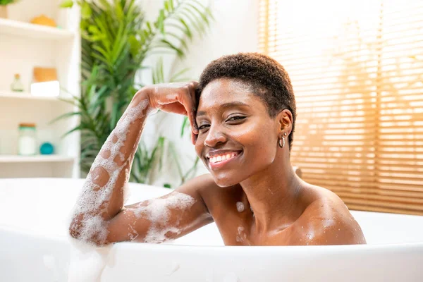 Beautiful woman taking bubble bath, smiling and looking to camera. Spa, wellness, relaxation concept. High quality photo