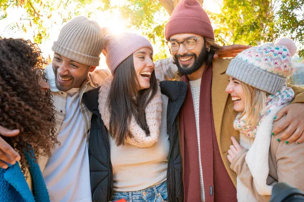 Young group of happy friends people having fun and laughing outdoors. Day of carefree, freedom, laughing together in the park in winter clothing.