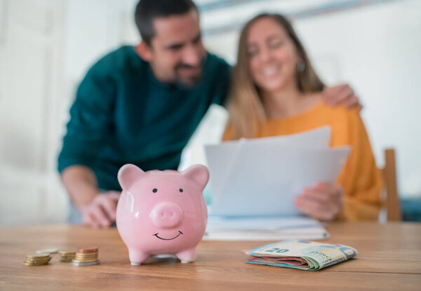 Excited young family couple managing home finances paying bills satisfied with successful results. Joyful husband wife celebrate planning of domestic budget or mortgage approval. High quality photo