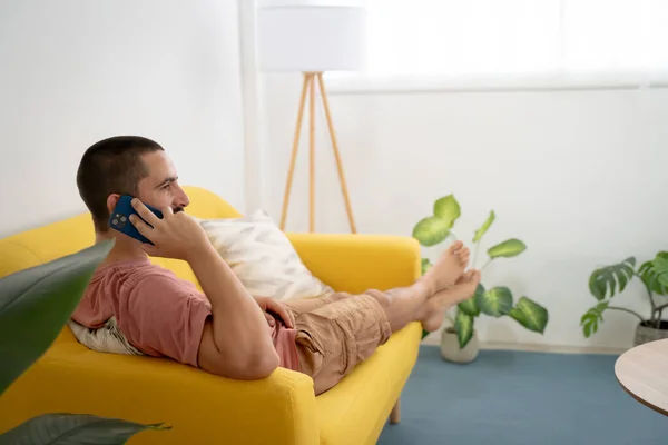Adam evde rahatça bir telefon görüşmesi yapıyor. Yüksek kalite fotoğraf