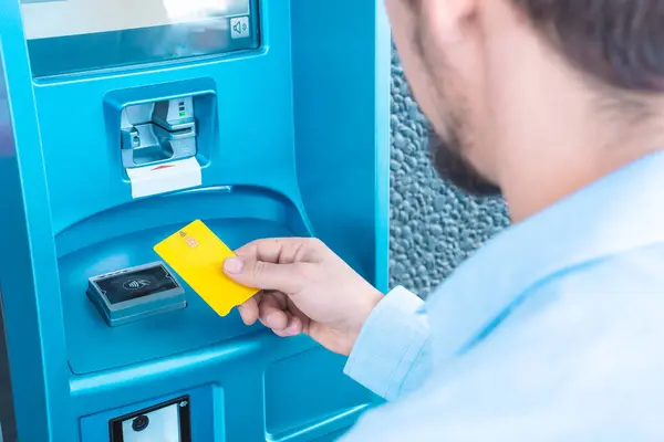 ATM kullanan adam kredi kartı işini paraya çeviriyor. Finans banka hesabı. Yüksek kalite fotoğraf