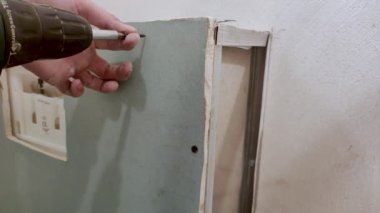 Pruszcz Gdanski, Polonya - 24 Ekim 2022: Alçıpan paneline vida takmak.