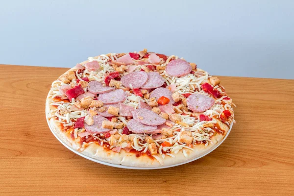 Frozen pizza on wooden table.