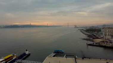 Lizbon, Portekiz - 3 Aralık 2022: 25 de Abril köprüsü (25 Nisan Köprüsü) ile Tagus Nehri üzerinde hava gün batımı manzarası).