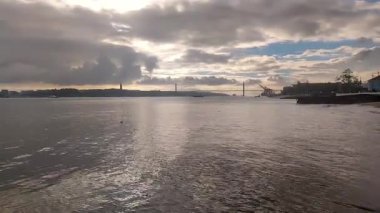 Sunset view on River Tagus with 25 de Abril bridge (25th of April Bridge) in background.