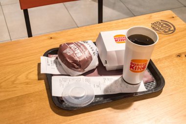Gardermoen, Norveç - 12 Aralık 2022 Biftek Lokantası Pastırma Kralı burger, acılı patates kızartması ve Pepsi Burger King restoranında içecek..