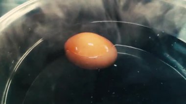 Siyah bir tencerede tavuk yumurtası pişirmek..